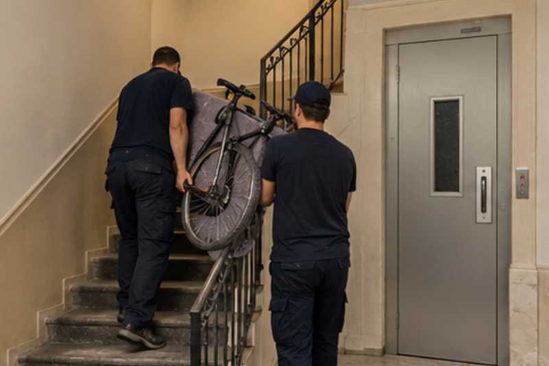 Un vélo de ville sous couverture de déménagement, dans une cage d'escalier d'immeuble, déménagement de Paris vers l'Albanie